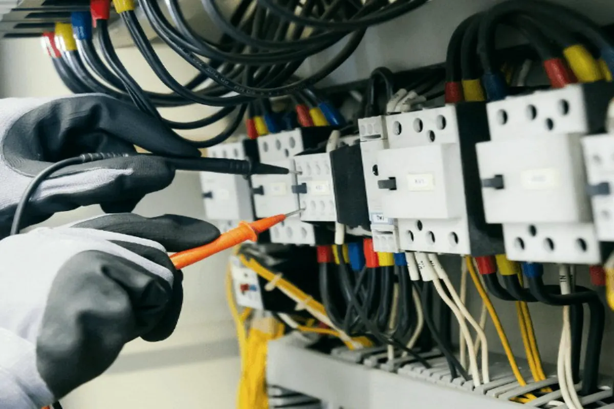 Electricista comprovant un quadre elèctric amb un mesurador
