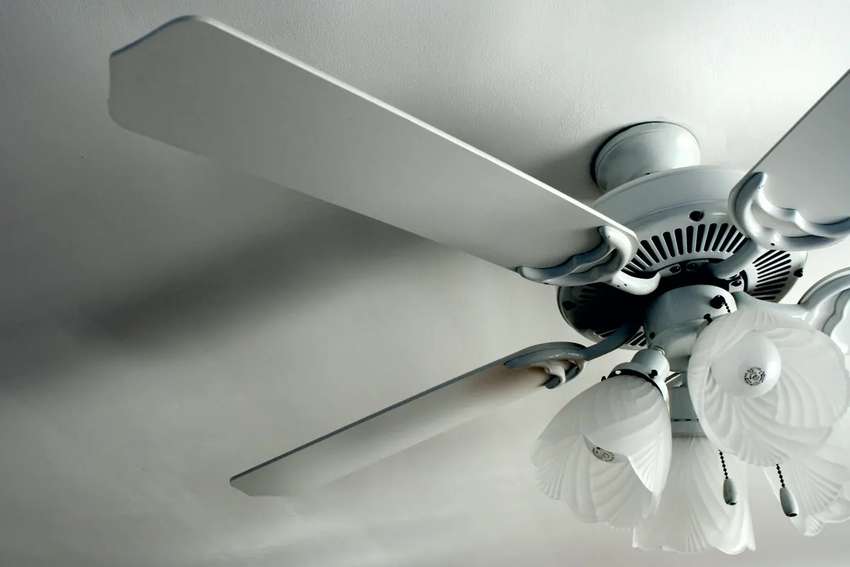 Ventilador de techo con luz en una habitación blanca